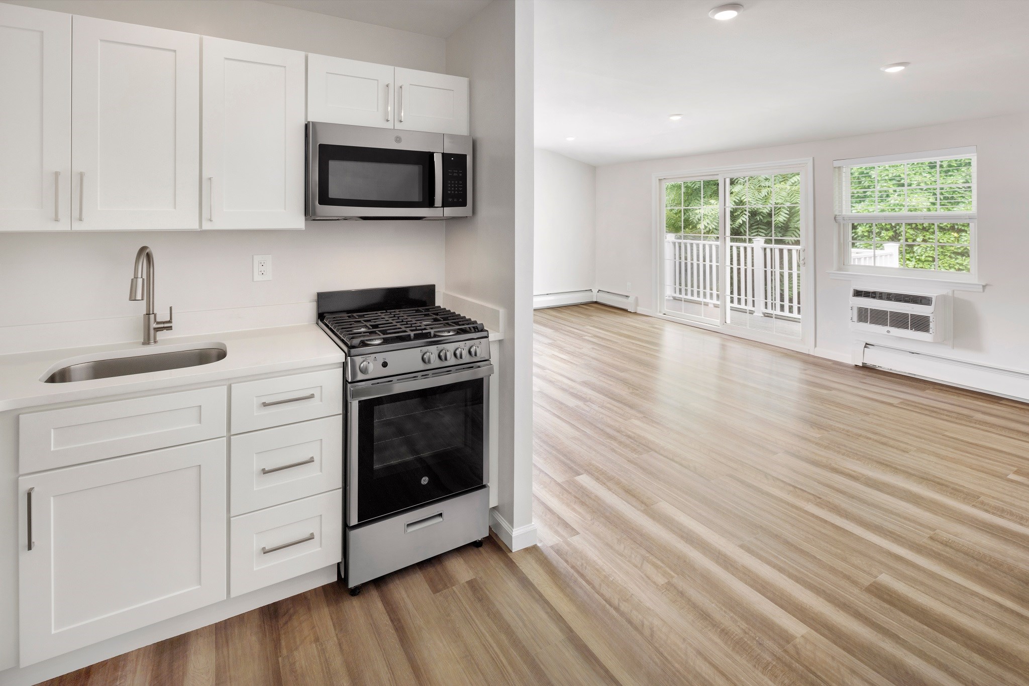 a kitchen with white cabinets and a stove and a microwave