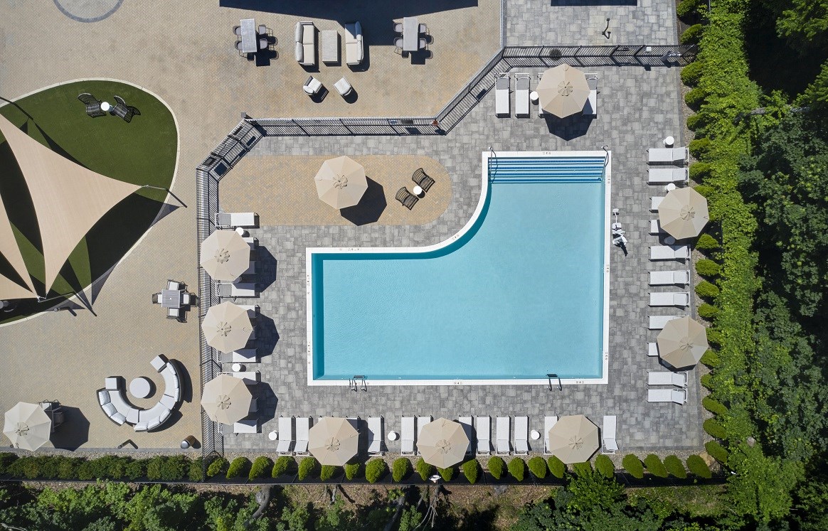 arial view of a swimming pool at a resort with umbrellas and tables
