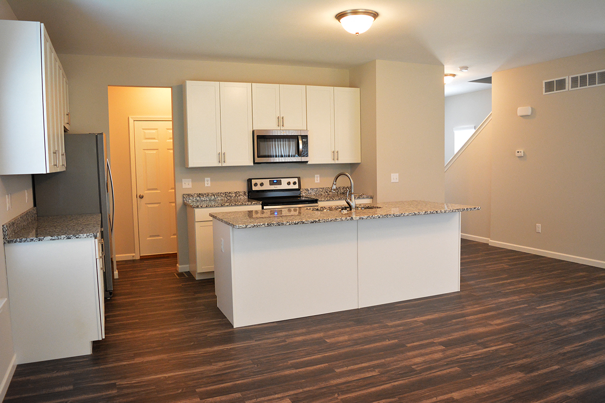 a kitchen with white cabinets and a counter top