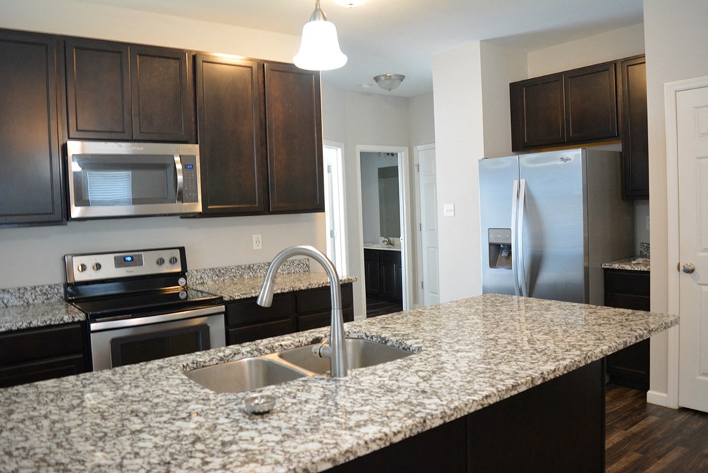 a kitchen with granite counter tops and stainless steel appliances