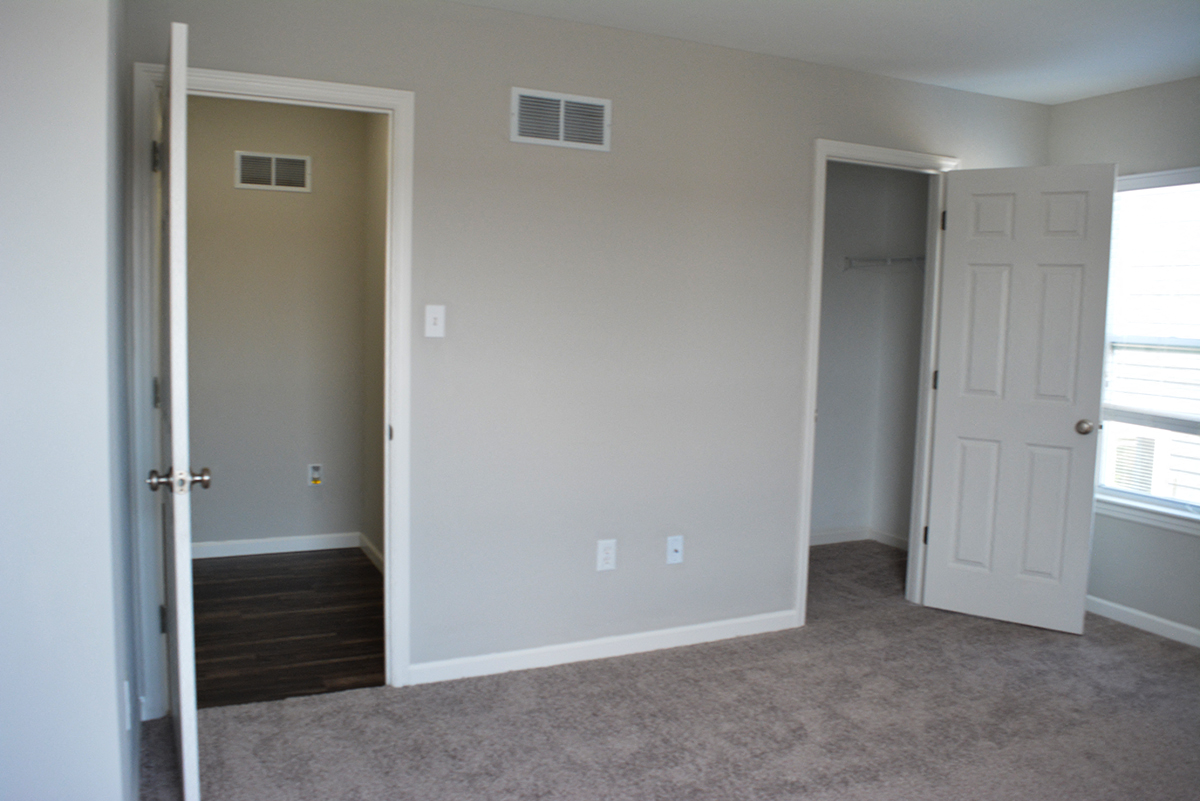 a bedroom with a door open to a hallway and a closet