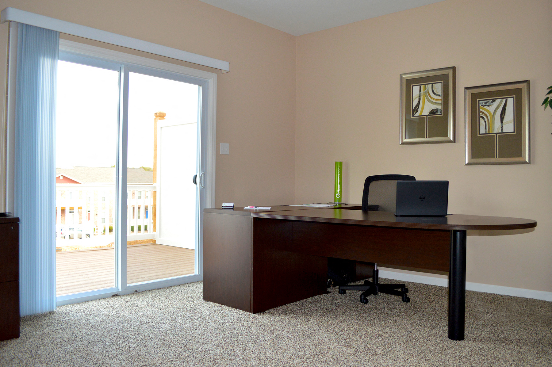 a home office with a desk and a sliding glass door
