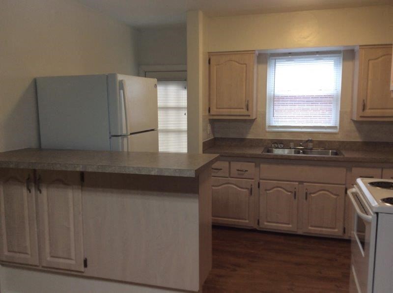 a kitchen with white cabinets and a sink and a refrigerator
