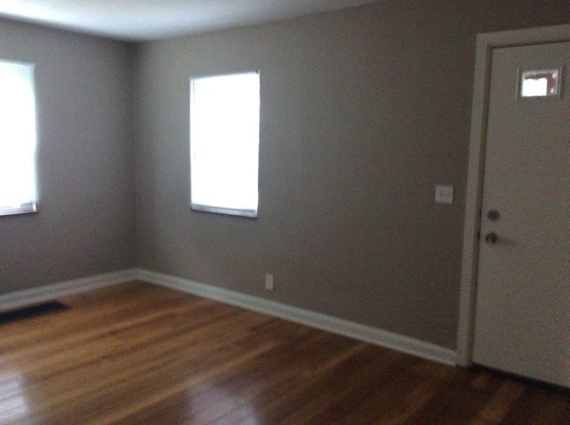 an empty room with a wooden floor and a door