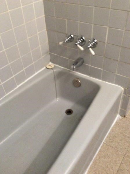 a white bath tub in a tiled bathroom