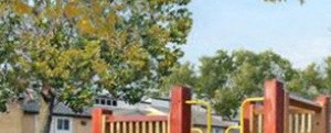 a playground with a slide and a building in the background