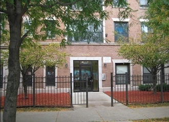 an apartment building with a black fence and a front door
