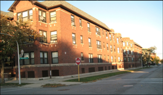 a large brick building on a street corner with a stop sign