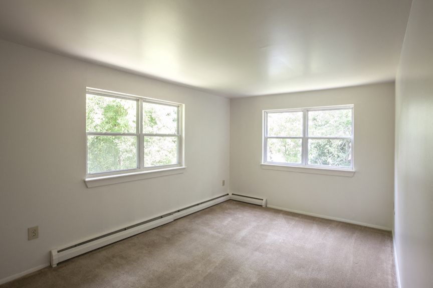 the living room of an empty house with two windows