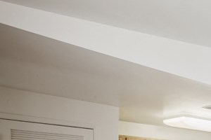 an empty living room and kitchen with wood flooring and white walls