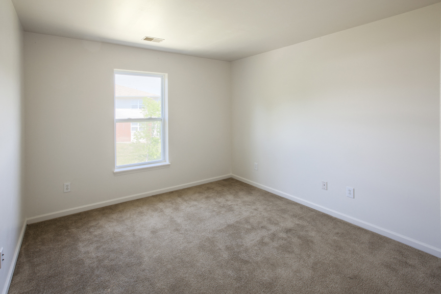 an empty room with carpet and a window