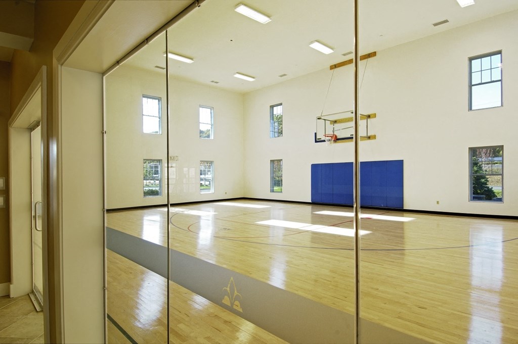 a large room with a basketball court and a glass door