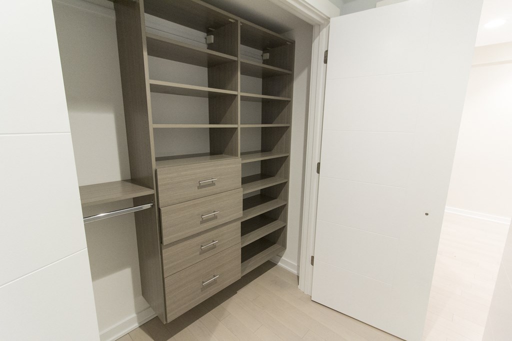 a large white wardrobe with shelves and drawers and a door open