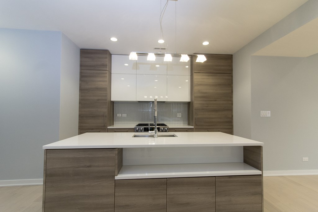 a kitchen with a white counter top and a sink