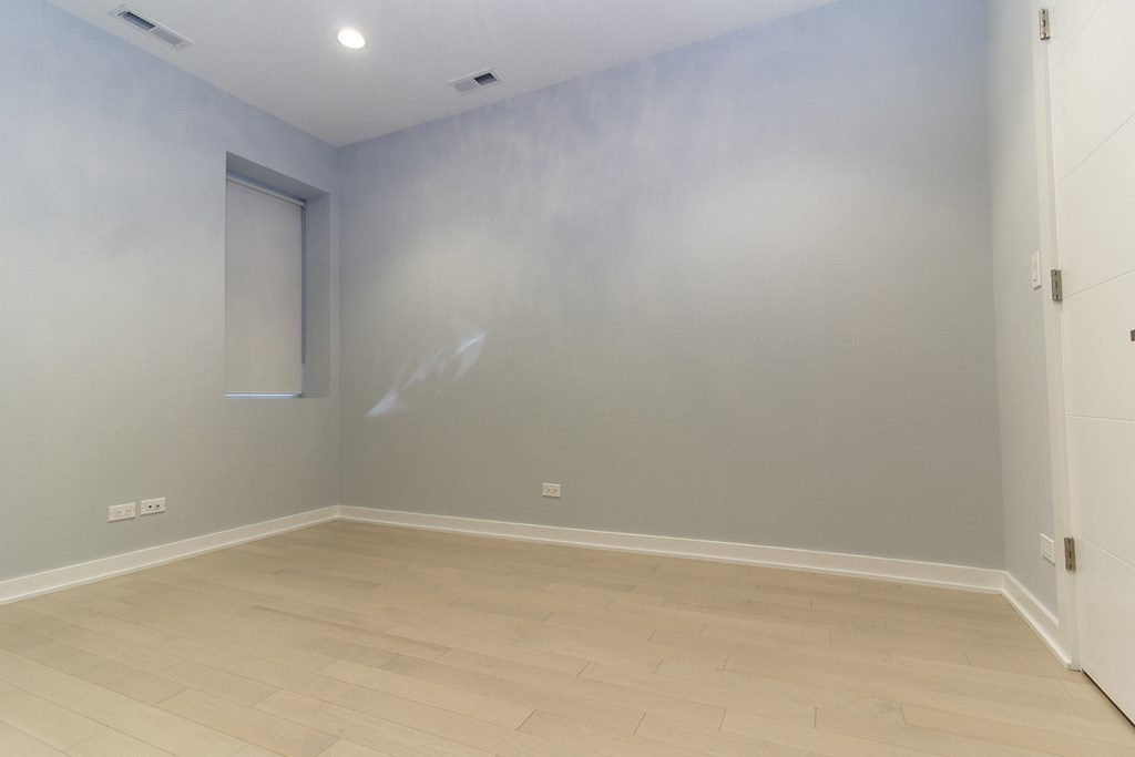 an empty room with a window and a wooden floor