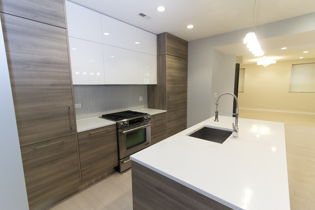 a modern kitchen with white counter tops and wooden cabinets