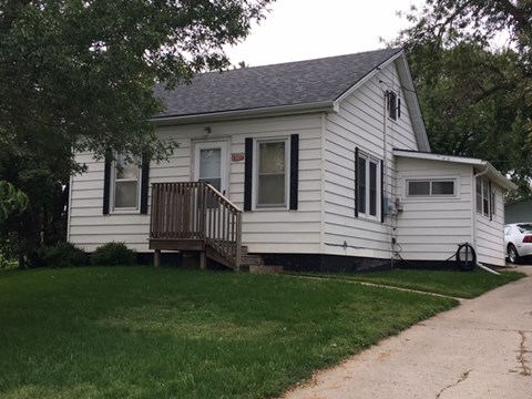 a white house with a wooden deck on the side of it