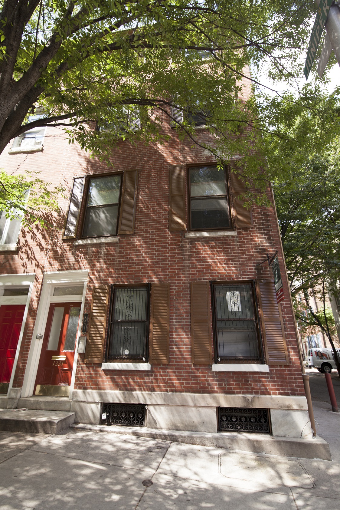 a red brick building with a tree in front of it