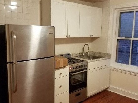a kitchen with a stainless steel refrigerator and a window