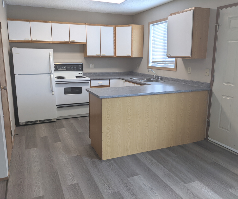 A kitchen with a white refrigerator, white oven, and white cabinets.