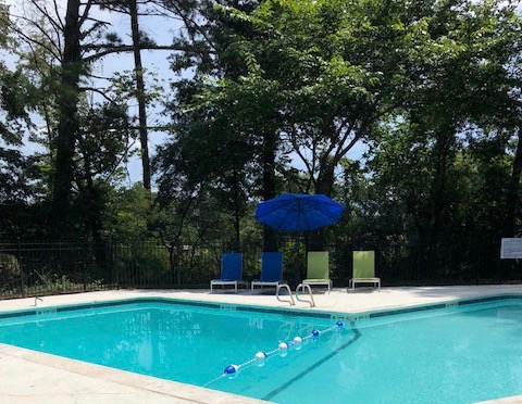a swimming pool with two chairs and an umbrella
