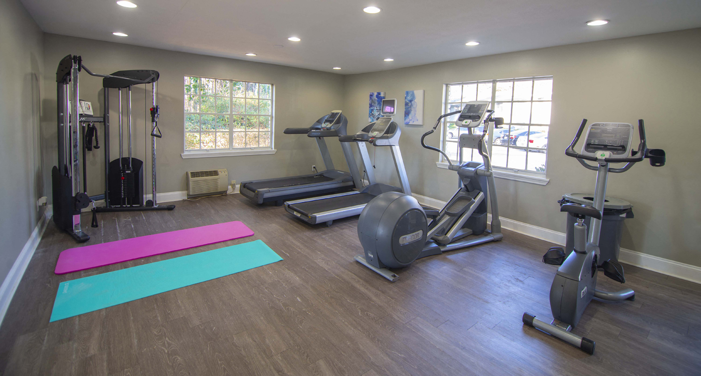 a gym with exercise equipment and yoga mats