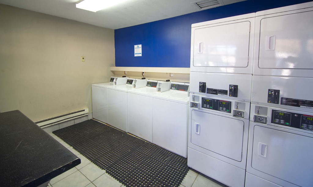 a laundry room with white machines and a blue wall