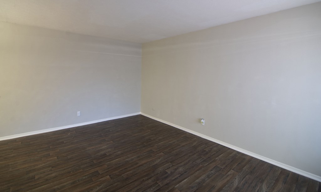 an empty room with wooden floors and white walls