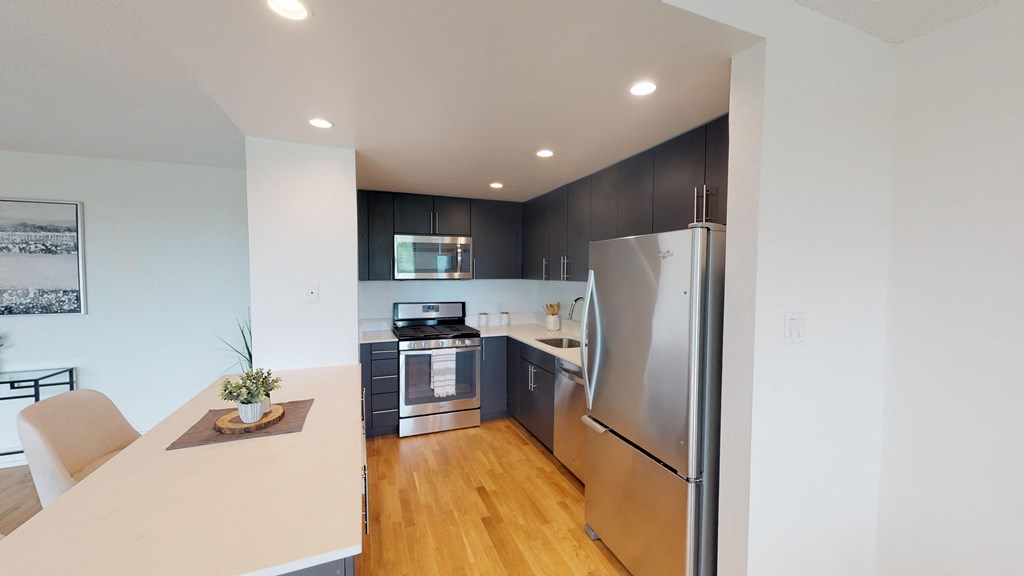 a kitchen and dining room with stainless steel appliances and wood floors