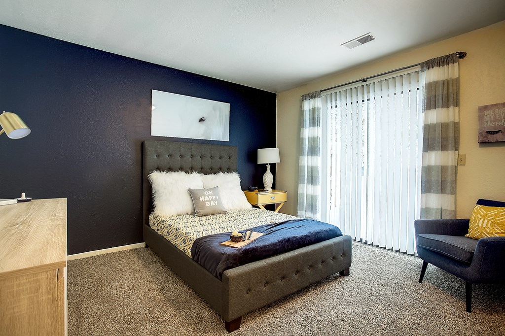 a bedroom with a bed and a blue accent wall