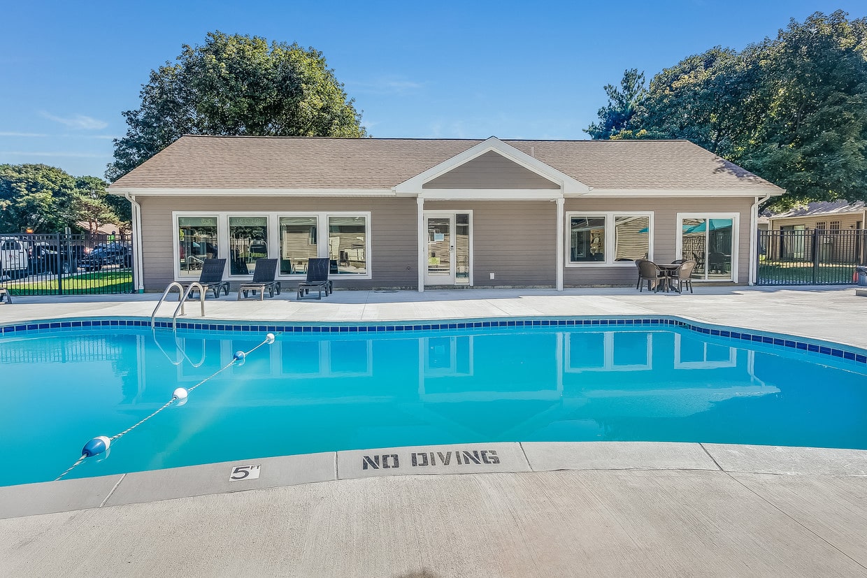 a swimming pool with a house in the background