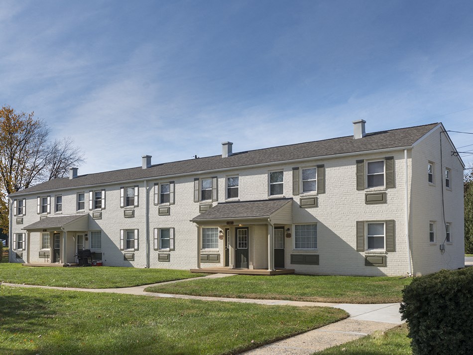 an apartment building with a sidewalk in front of it