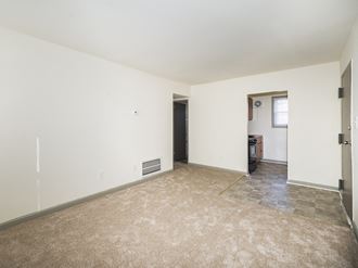 an empty living room with white walls and a tiled floor
