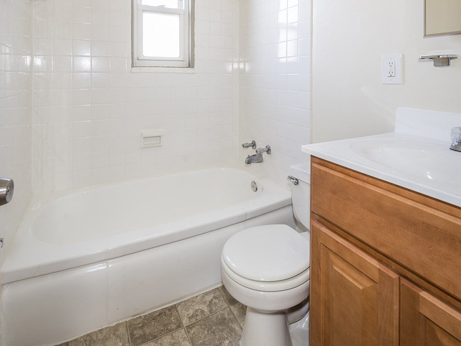 a bathroom with a toilet and a tub and a sink
