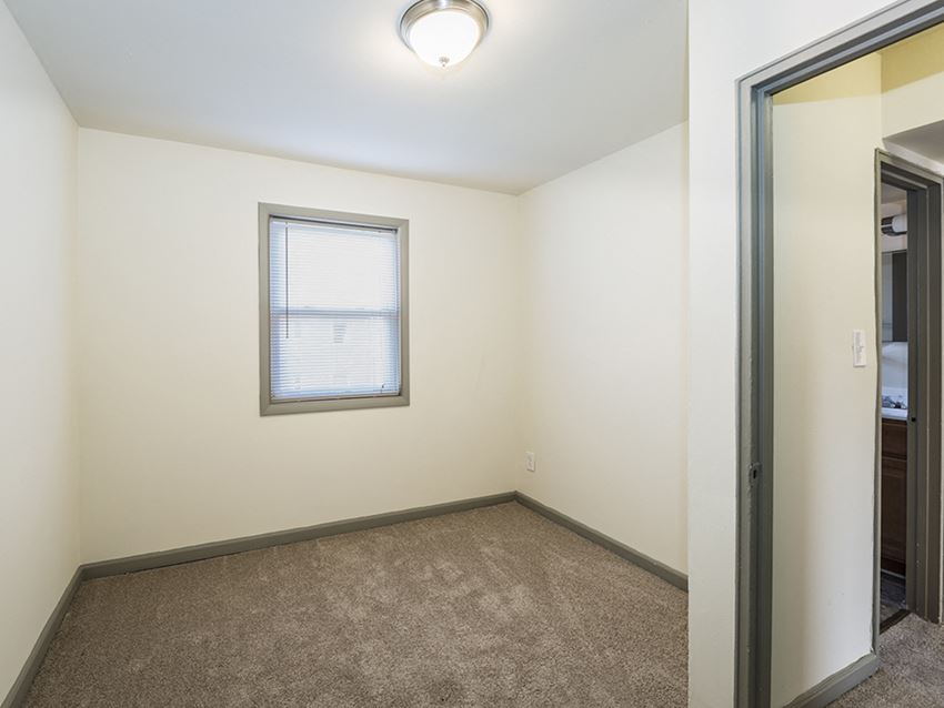 an empty room with a window and a mirror