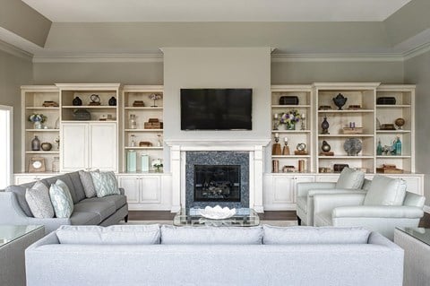 a living room with white furniture and a fireplace