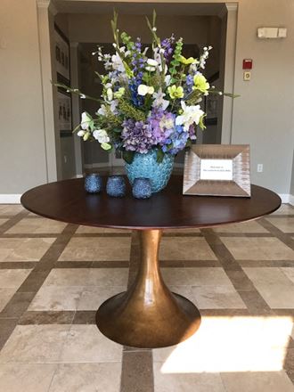 a round table with a vase of flowers on it