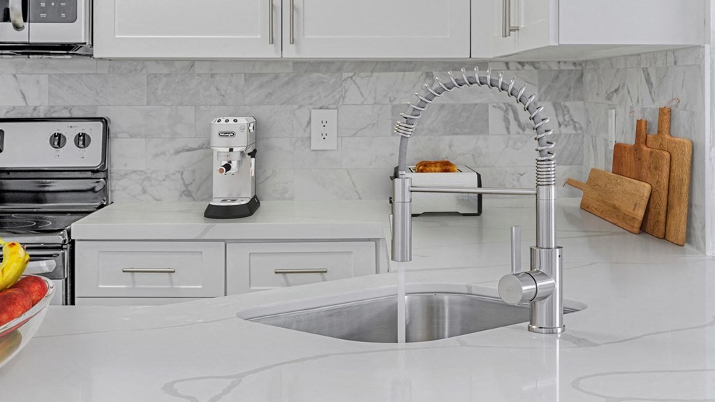 a white kitchen with a sink and a coffee maker