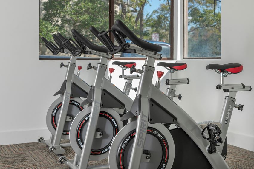 a row of spin bikes in a gym