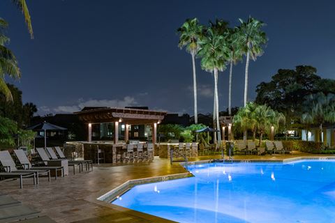 a swimming pool at night at a resort with palm trees