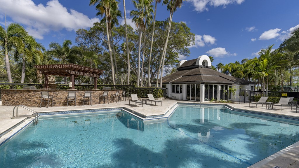 a swimming pool with chairs and a pavilion in front of a house