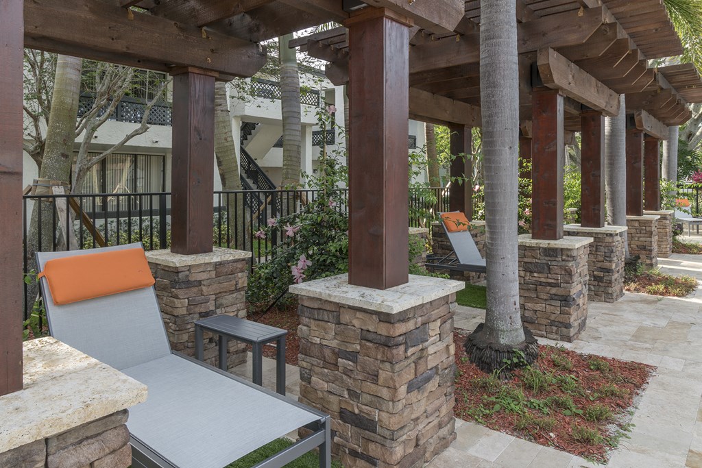 a patio with stone pillars and a table and chairs