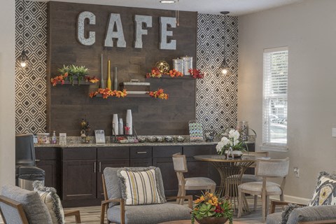 a cafe with chairs and a table and a sign on the wall