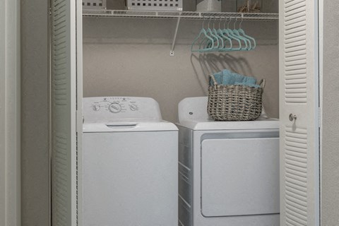 a white washer and dryer in a small laundry room