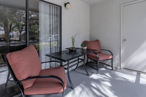 a balcony with a table and chairs and a sliding glass door
