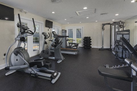 a gym with cardio machines and weights on the floor