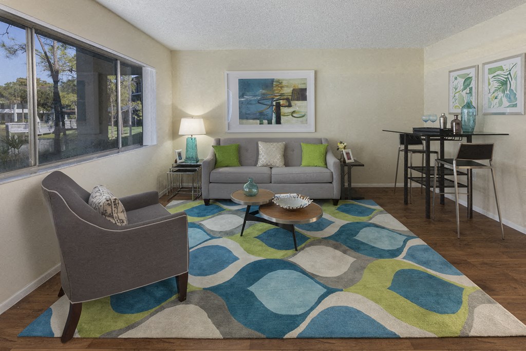 a living room with a couch and chairs and a rug