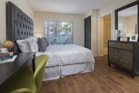 a bedroom with a bed and a desk and a window