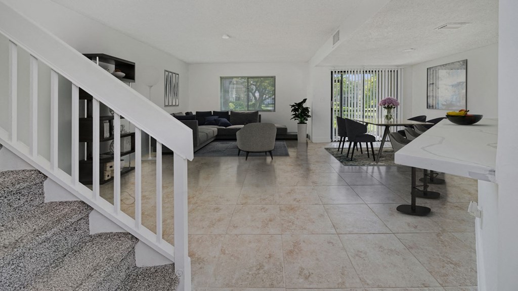 the living room and dining area of a house with a staircase