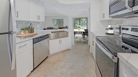 a large kitchen with stainless steel appliances and white cabinets
